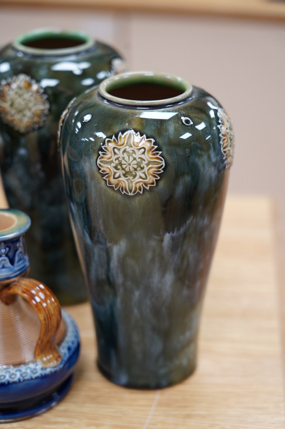 Seven Royal Doulton mixed vases etc, including two candlesticks, a pair of vases, a beaker, etc, tallest 21cm. Condition - the two handled pedestal jar has lost its lid, the other items are good